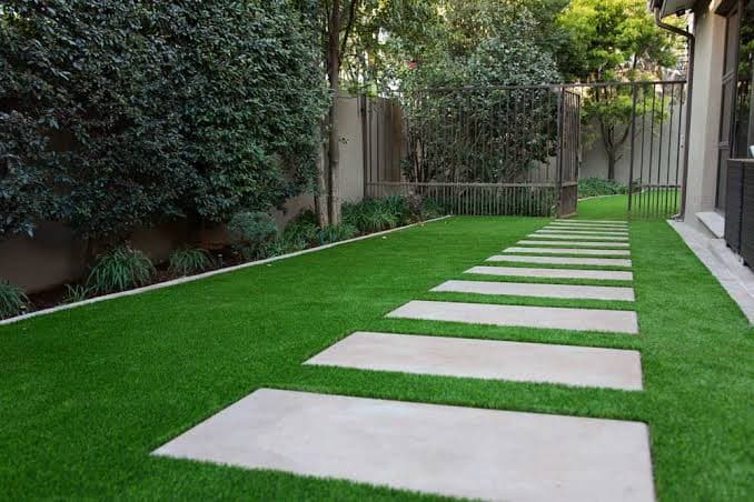 Paver garden path with stepping stones set in artificial turf beside a Bay of Plenty home