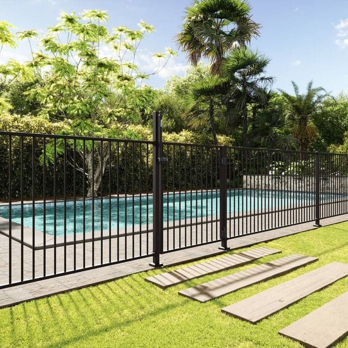 Black flat-top pool fence beside artificial turf and timber sleeper steps in a backyard